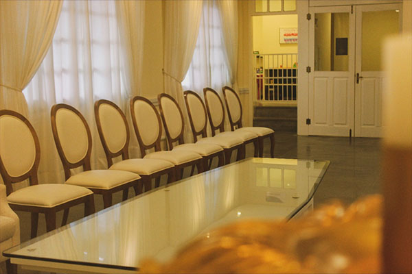 Detalhe de sala com velas e cadeiras